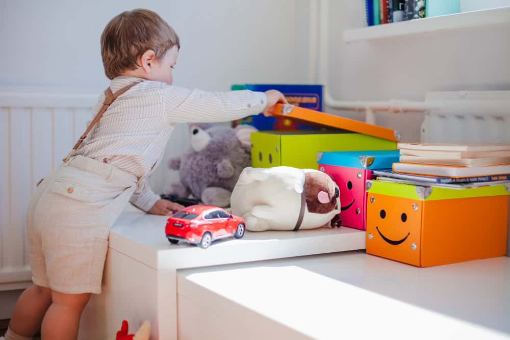 child tidying toys