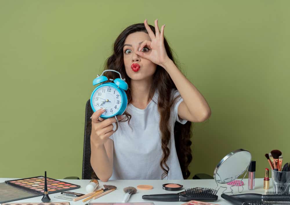 woman with makeup on and holding a clock